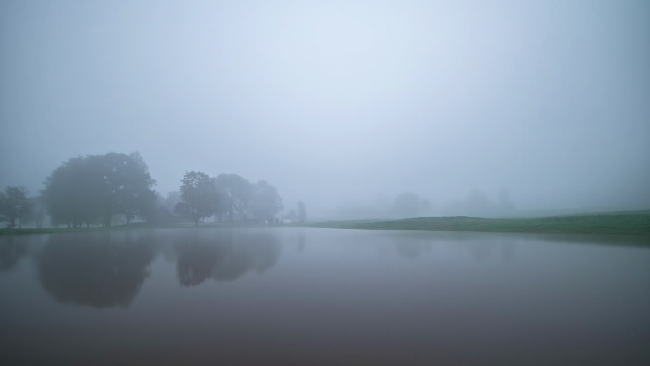 Time lapse of the year with its dates and climatic seasons, spring, summer, autumn and winter in fast motion of the landscape of a cabin in front of a lake in the middle of the forest with sunsets