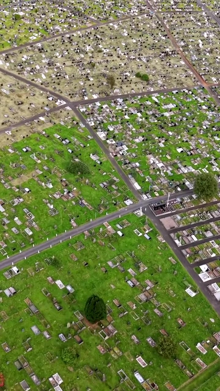 Vídeo aéreo ascendente do Cemitério de Milltown em West Belfast, Irlanda do Norte, numa noite de verão brilhante. Produzido em 60FPS, proporção social 1080x1920 e com cor Rec709