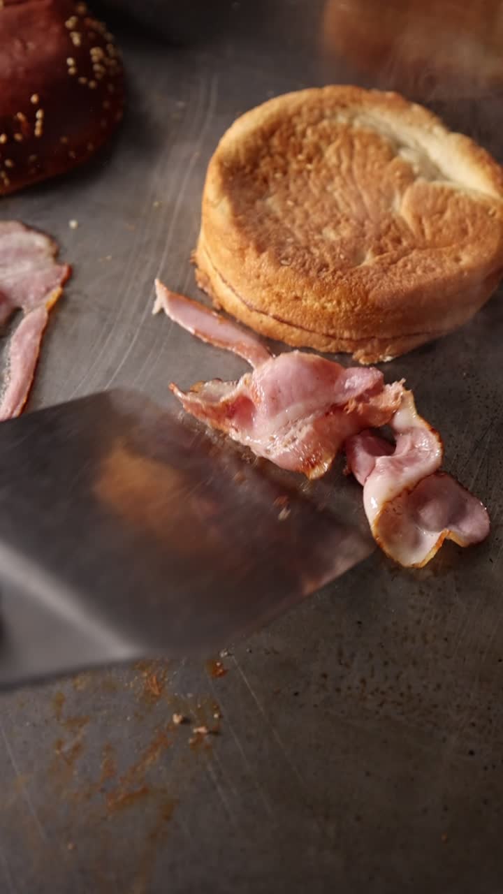 Chef che taglia la pancetta su una piastra calda per un hamburger