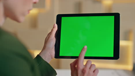 girl finger swiping greenscreen tablet close up. unknown woman surfing internet