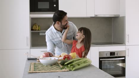 Padre-Feliz-Y-Pequeña-Hija-Cocinando-Ensalada-Juntos