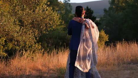 happy indian couple on nature during sunset