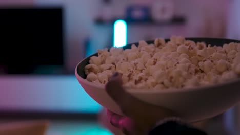 mujer corriendo con palomitas de maíz en la sala de estar
