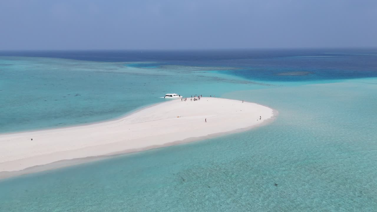 Riprese aeree con drone di un'isola con bancata di sabbia bianca in una laguna turchese, Maldive 4K