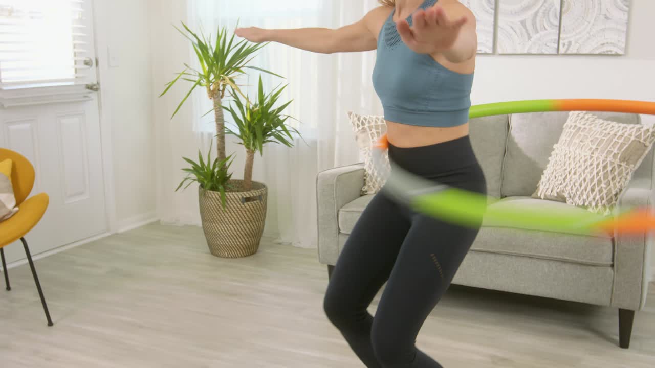 una chica hermosa con un buen cuerpo gira un gran aro en la cintura