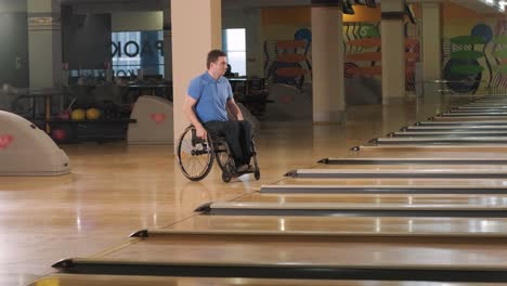 two young disabled men in wheelchairs playing bowling in the club