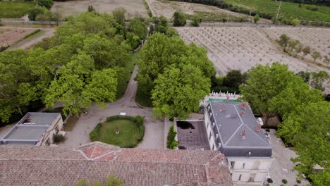 aerial establishing shot of a villa in the south of france surrounded by a vineyard