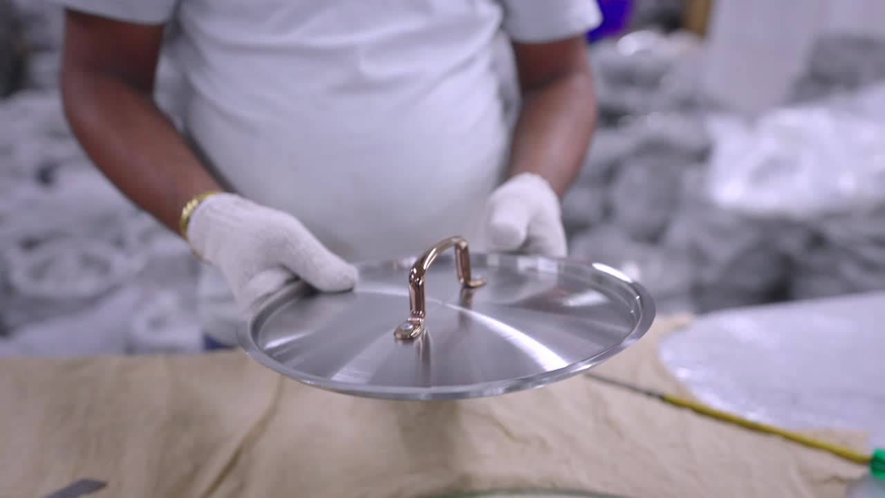Lucidatura e imballaggio di pentole in acciaio in una fabbrica di articoli da cucina