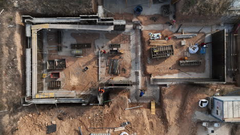 aerial view looking down over construction crew working on property foundation site