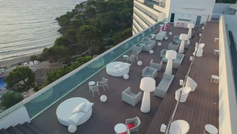 drone hovers over the hotel's terrace, lifts, reveals balearic sea