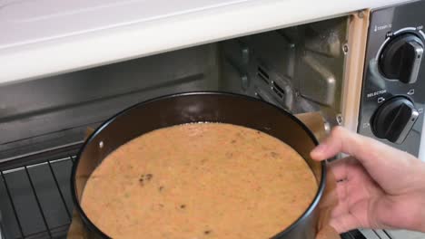 inserting the cake tray into the oven.top view