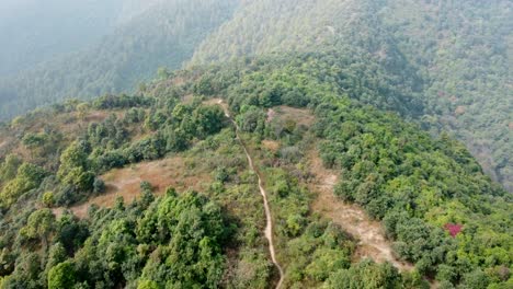 Flying-above-a-trail-on-a-mountain-ridge-on-a-very-hazy-autumn-day