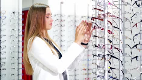 lovely woman choosing glasses at optics store. beautiful girl buying new glasses. eyesight and health care concept.