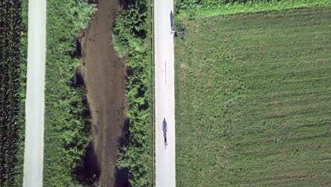 Aerial-top-view-above-a-biker-in-Sugana-Valley,-Italy-with-drone-flying-up