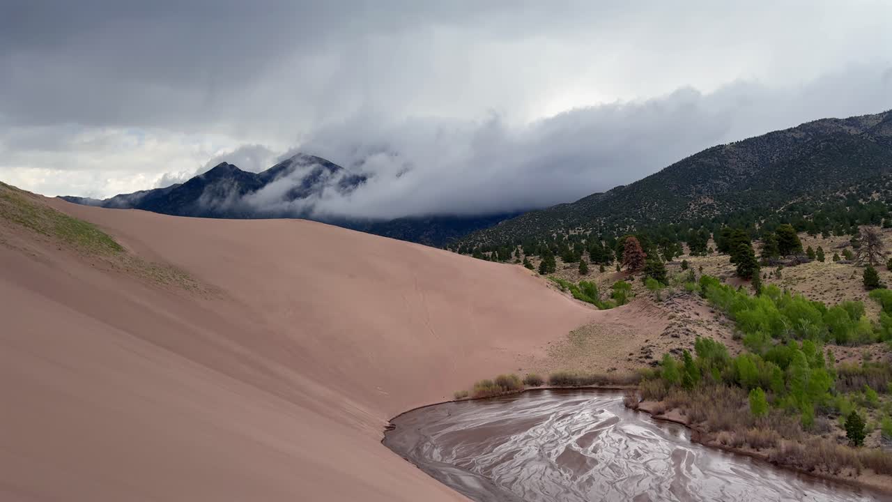 Medano Creek Great Sand Dunes National Park Sangre de Cristo range Rocky Mountains spring summer raining cloudy Colorado unique magical large amounts of sand dune hills windy landscape Crestone Needle