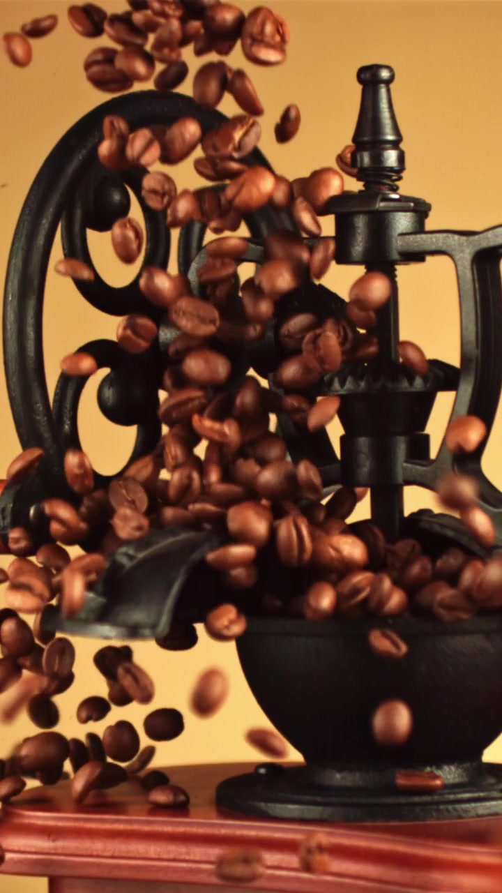 Chicchi di caffè tostati che cadono in un macinacaffè vintage