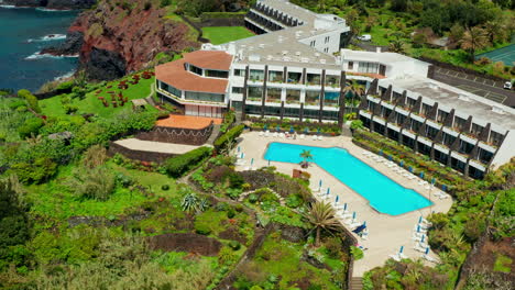 Cinematic-aerial-drone-shot-of-a-beautiful-resort-located-on-top-rocky-coastline-in-Sao-Miguel-island,-Azores---Portugal