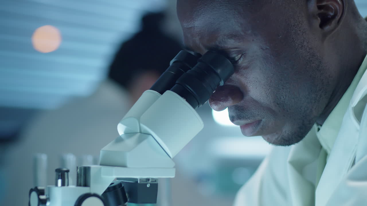 Lab Scientist Examining Sample through Microscope