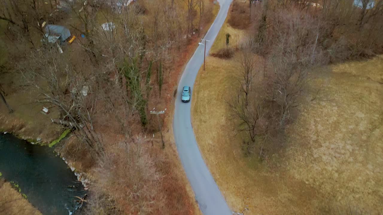 Aerial View of vehicle traveling down pathway with trees