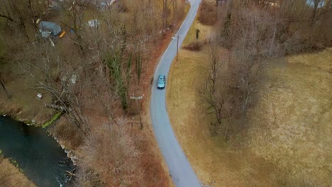 aerial view of vehicle traveling down pathway with trees