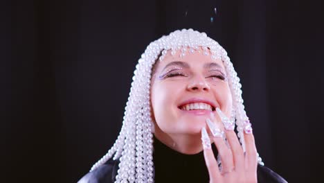 woman with pearl headpiece and glitter makeup laughing