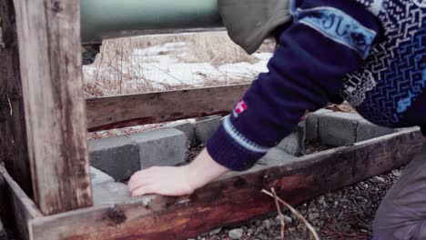 the man is compacting the concrete blocks beneath the diy hot tub - close up