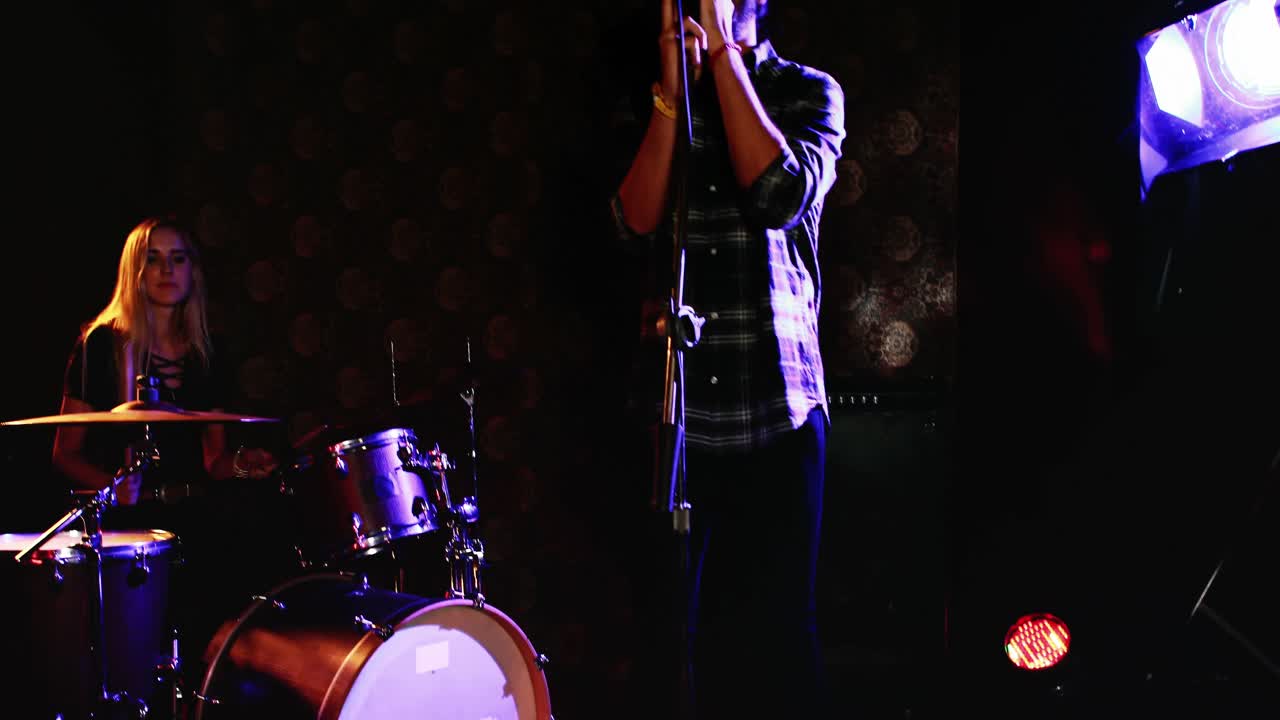 Uomo che canta una canzone mentre la donna suona la batteria 4k