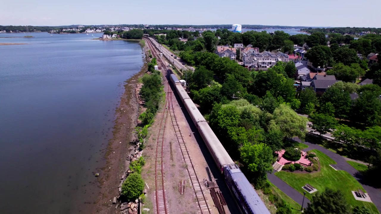 Un treno passeggeri pendolare lascia una stazione vicino ad appartamenti a Salem, Massachusetts