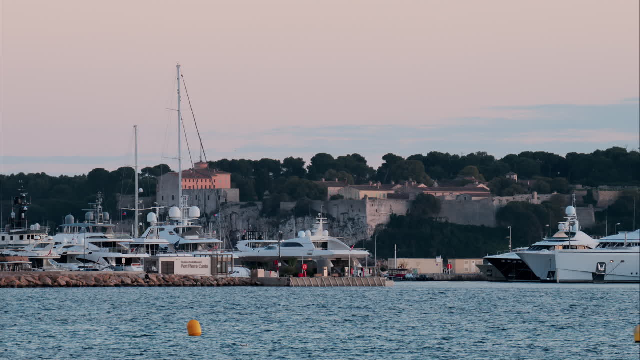 Multiple boats docked in the Port Pierre Canto in Cannes, France in the evening