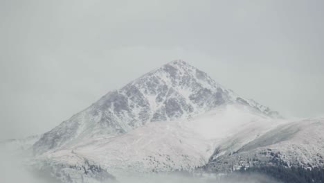 mountain summit appearing out of the fog a low-level clouds in kyrgyzstan