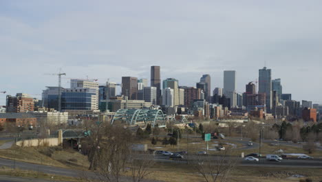 downtown denver - vehicles driving in the road with high-rise building in background in denver, colorado, usa