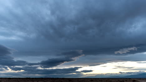 Capas-De-Nubes-En-Un-Día-Tormentoso-Moviéndose-En-Diferentes-Direcciones-Debido-A-Una-Cizalladura-De-Viento-Sobre-El-Paisaje-Desértico-Al-Atardecer---Lapso-De-Tiempo