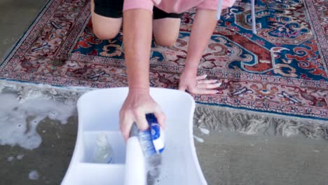 hand scrubbing an oriental or persian carpet with soap and water - close up