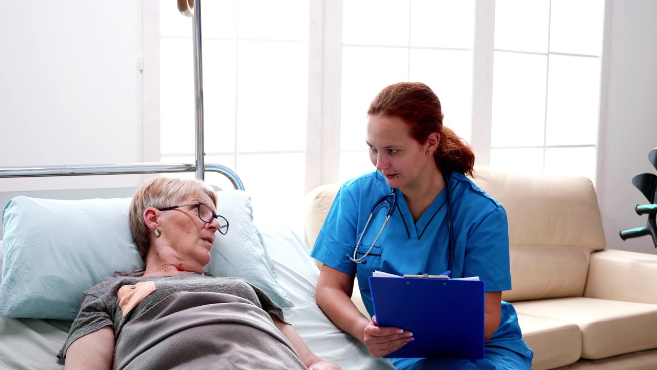 Nurse Consulting with Elderly Patient in Hospital Bed