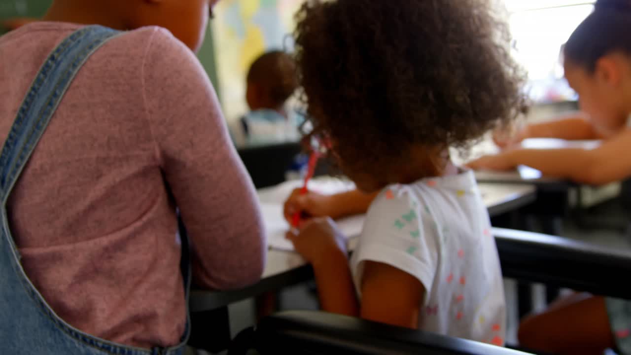 Disabled schoolgirl studying at desk in classroom at school 4k
