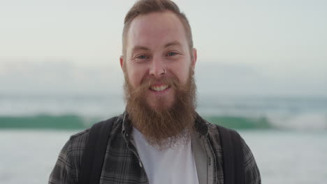 Retrato-De-Un-Joven-Barbudo-Sonriendo-Mirando-La-Cámara-En-La-Playa-Disfrutando-De-Un-Estilo-De-Vida-Positivo-Atractivo-Hombre-Hipster-En-La-Playa