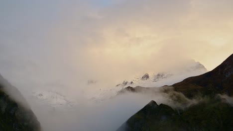 nepal mountains in sunset clouds in moody atmospheric scene of annapurna mountain range in himalayas with beautiful dramatic orange sunset sky with peaks in the clouds