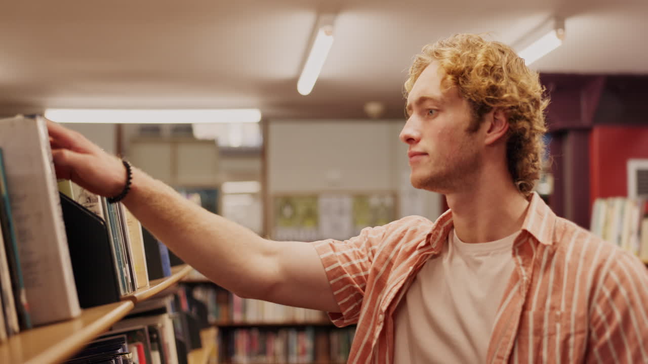 hombre revisando libros en una biblioteca