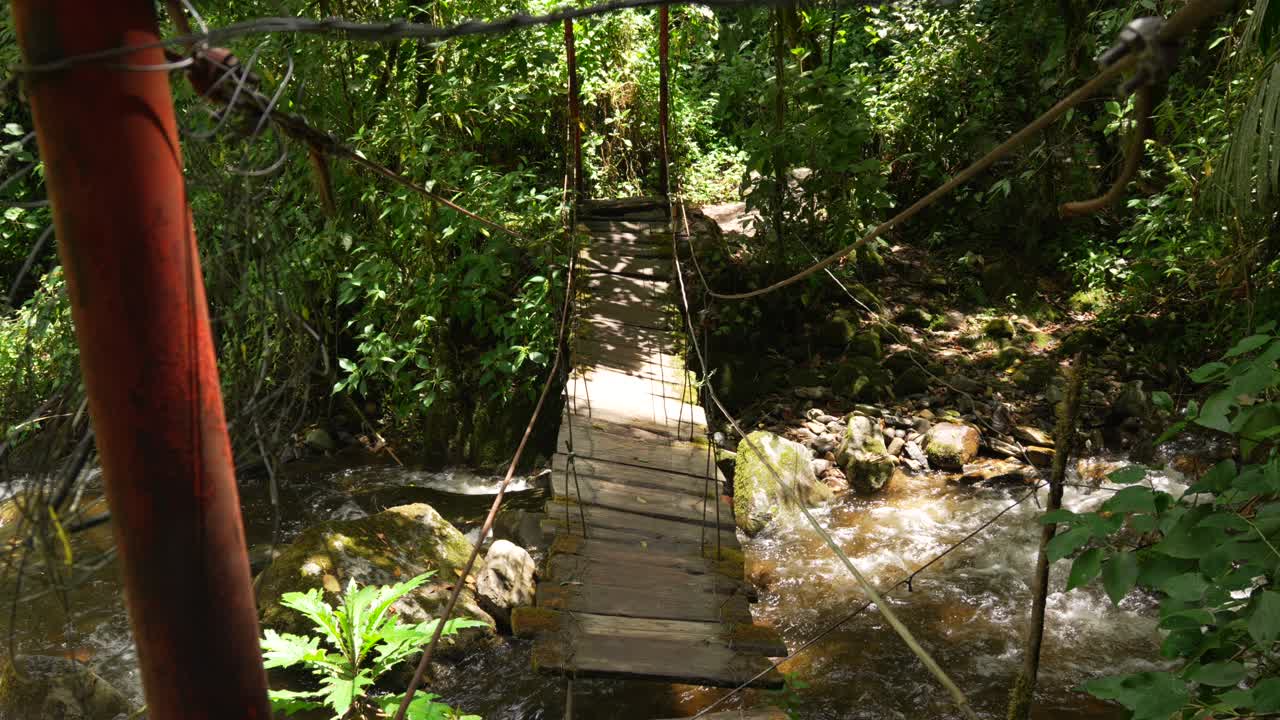 Suspension bridge in the Cocora Valley in Colombia over river creek water stream