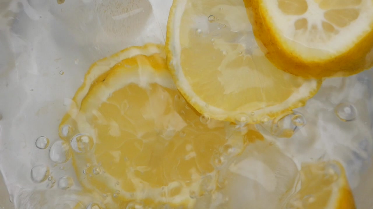 Overhead View of Lemon Slices and Ice Cubes Splashing in Water