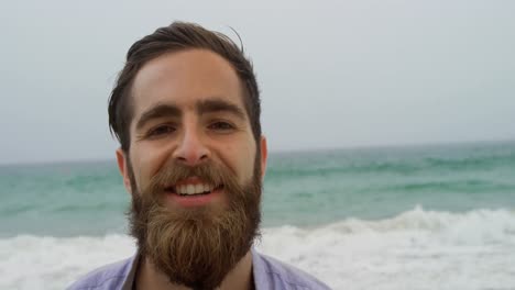 vista frontal de un hombre caucásico de pie en la playa 4k
