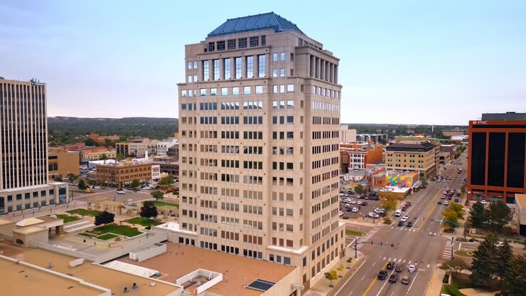 Colorado Springs, EUA, 22 de julho de 2025: Aproximação do belo edifício de vários andares no centro de Colorado Springs, Colorado, EUA. Vista da estrada com várias faixas e carros.