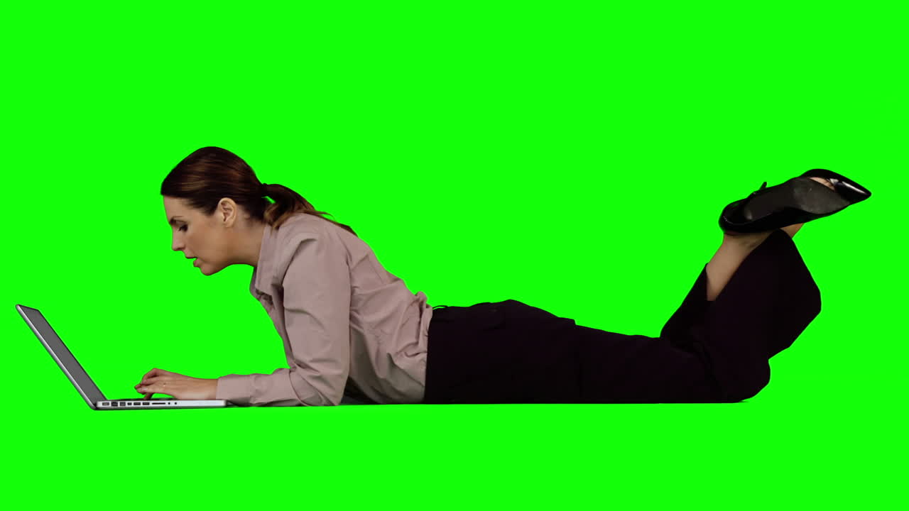 mujer de negocios usando portátil contra pantalla verde