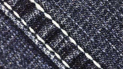 white straight stitches across denim fabric -macro