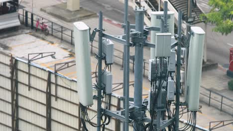 torre de antena de telecomunicaciones 5g en un techo en bangkok, tailandia con tráfico en el fondo, ángulo alto en verdadero 4k dc