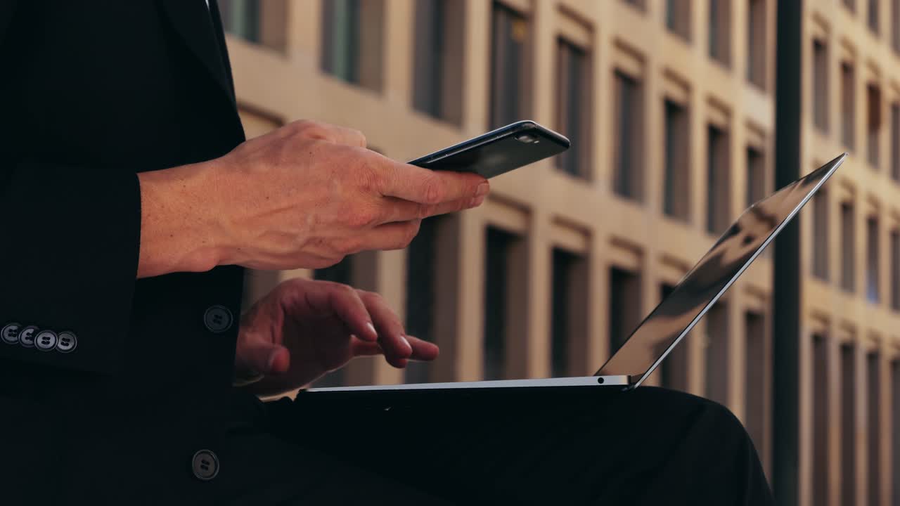 Asian businessman using laptop computer in the park, man working outdoor near modern office. Park street airport terminal
