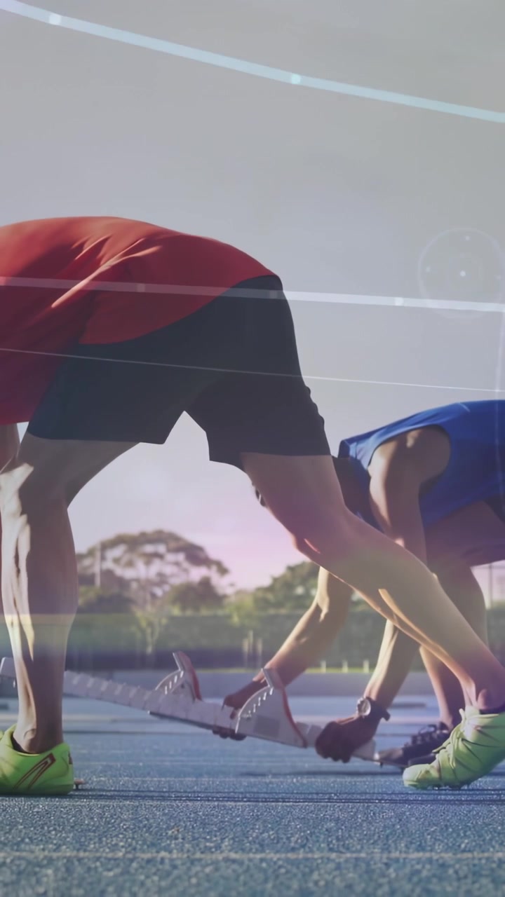 Video dọc: Hai vận động viên nam điều chỉnh bàn đạp xuất phát trên đường chạy màu xanh, lớp phủ báo hiệu bắt đầu chạy nước rút.