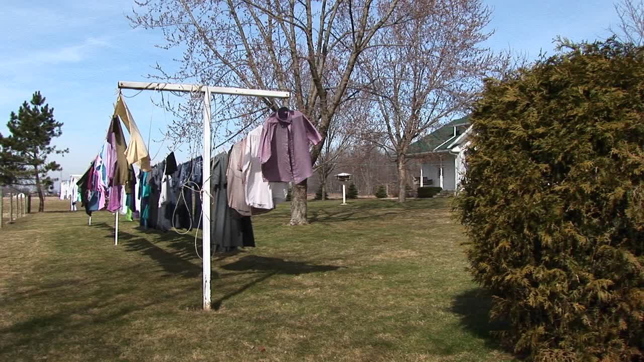 옷은 햇빛에 말리기 위해 야외 빨랫줄에 걸려 있다