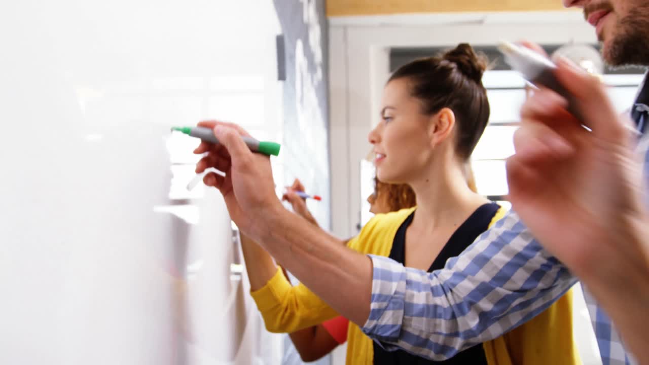 grupo de ejecutivos de negocios escribiendo en una pizarra