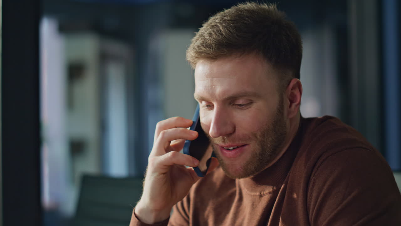 Successful ceo taking cellphone answering call in modern workspace closeup